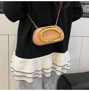 Close-up of pink leather handbag featuring a large gold C logo and metal chain strap