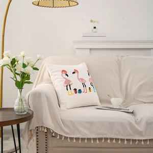 Summer cartoon flamingo embroidery cushion cover with fringe on a creamy sofa