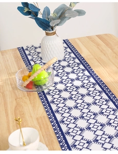 Modern Nordic table runner with blue and white geometric patterns on a wooden dining table