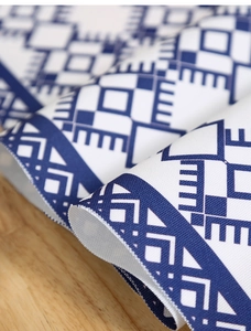 Close-up of modern table runner fabric showing blue geometric patterns on light wood