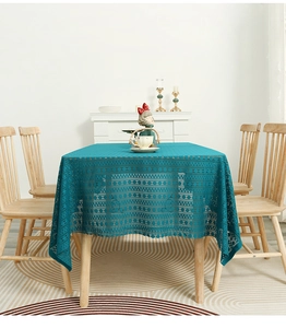 Detailed macro view of teal rectangular tablecloth with hollow lace geometric patterns