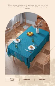 Close-up of teal lace tablecloth with hollow patterns and decorative fringe trim