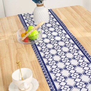 Blue geometric pattern table runner with tassels on a wooden table for home decor