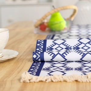 Nordischer gewebter Tischläufer mit blauen geometrischen Mustern und Quasten auf Holztisch