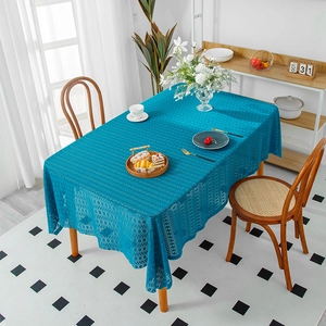 Elegante dunkelblaue Tischdecke aus Spitze in Rechteckform auf einem Esstisch aus Holz