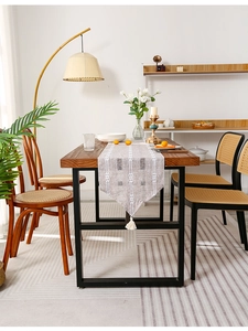 Detail of striped table runner with fringe on a wooden dining table in a cozy home setting