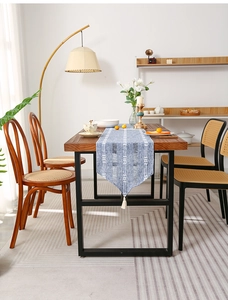 Detail of blue and white woven table runner featuring geometric patterns and white tassels