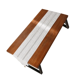 Modern Nordic striped table runner with white geometric weave and fringe on wood table