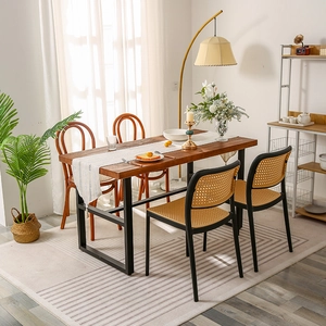 Modern minimalist dark wood dining table with black metal legs and rattan woven chairs