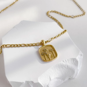Vue macro détaillée d'un pendentif rectangulaire doré avec trois motifs floraux