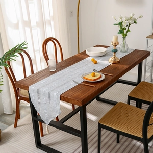 Noordse lichtgrijze gestreepte tafelloper met kwastjes op houten eettafel decoratie