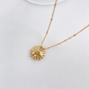 Detailansicht der Rückseite des goldenen Gänseblümchen-Anhängers und der Perlenkette