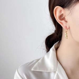 Boucles d'oreilles artistiques en or avec pendentif torse et perles sur mannequin