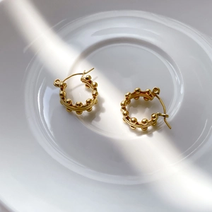 Detail of gold beaded hoop earrings featuring a French vintage textured metal design
