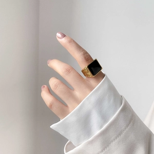 Close-up of a vintage square black onyx signet ring with gold textured side bands