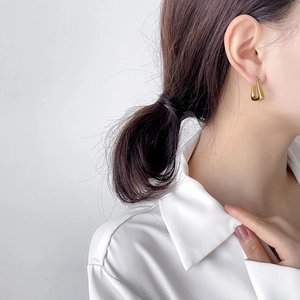 Minimalist gold U-shaped earring shown on model for a sleek geometric daily look