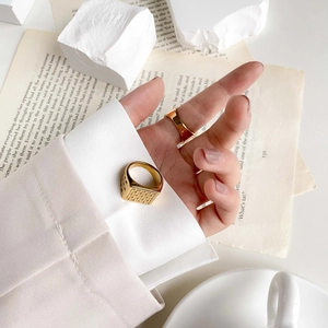 Macro detail of gold textured signet ring with vintage grid pattern and polished finish