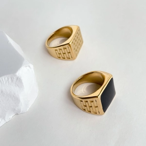 Detail of gold-plated signet rings with black enamel square and geometric textures