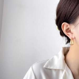 Minimalist gold-plated rectangular U-shape hoop earrings worn by a model