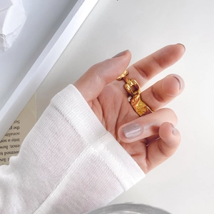 Close-up of gold-plated chain link ring and hammered texture band on model's hand