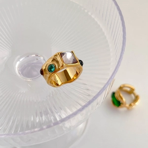 Detail shot of vintage gold ring with square purple stone on glass tray