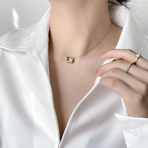 Elegant gold necklace with a square yellow zircon pendant worn with matching rings