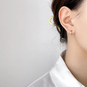 Close-up of 18K gold star ear cuff with sparkling zircon and fine engraving on ears