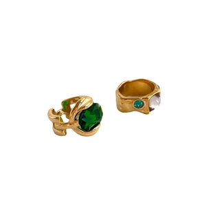 Luxury gold ring set featuring large oval emerald gemstone and rectangular crystals