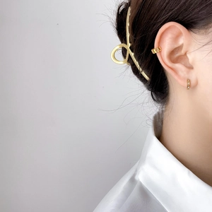 Golden star ear cuff and minimalist hair claw clip set worn by a female model