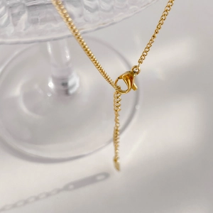 Close-up of gold lobster clasp and adjustable extension chain on heart necklace