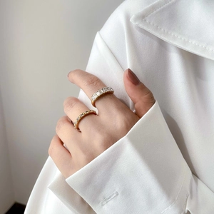 Close-up of elegant gold zircon rings on finger with rectangle cut stones for women