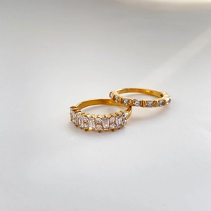 Macro shot of two luxury gold rings set with sparkling zircon in a minimal chic style