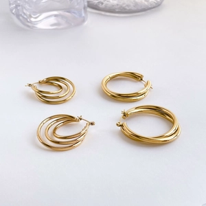 Detailed view of layered gold hoop earrings with polished intertwined ring design