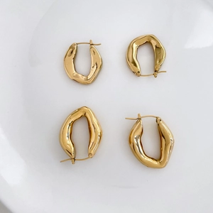 Vue détaillée de deux paires de boucles d'oreilles dorées avec texture métal liquide