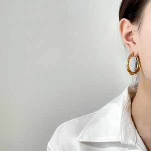 Elegant multi-layered gold hoop earrings shown on a model for minimalist jewelry style