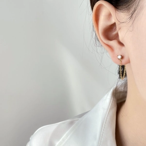 Detailed view of a gold chain drop earring featuring a sparkling black zircon stone