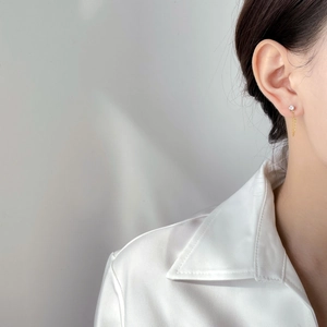 Elegant gold tassel chain earrings with clear zircon stone shown on a model side view