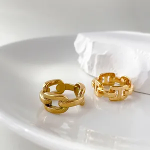 Detail of two gold-plated chain link rings Style A and B on a minimalist background