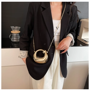 Golden mirror metallic horseshoe mini crossbody bag with delicate chain strap on model