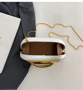 Top view of white oval box bag showing spacious interior with golden chain and handle