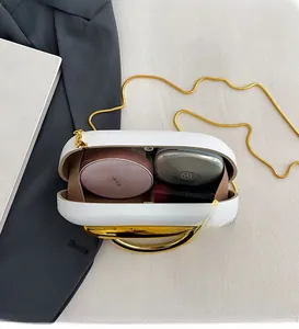 Interior view of white shell clutch bag showing space for cosmetics and gold chain