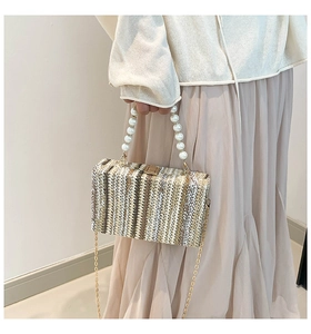 Close-up of multicolored woven straw bag with faux pearl handle and metal chain strap