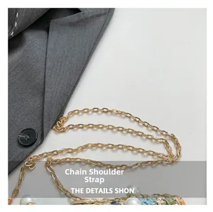Close-up of woven bag featuring golden chain strap with decorative white pearls
