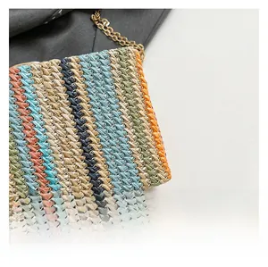 Detail of colorful striped straw shoulder bag with a premium golden chain strap