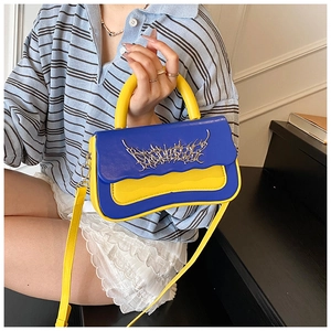 Detail of color-block mini handbag with silver thorn ornament and yellow strap