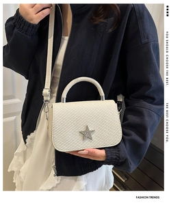 Detail view of mini off-white crossbody bag with star rhinestone and twill texture