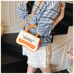 Detail of trendy color-block crossbody bag featuring street-style graphic text design