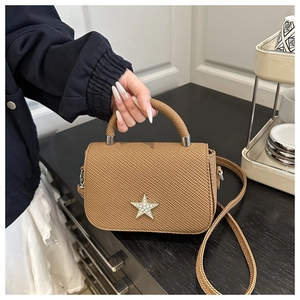 Details der braunen gewebten Tasche mit glitzerndem Sternemblem und rundem Tragegriff