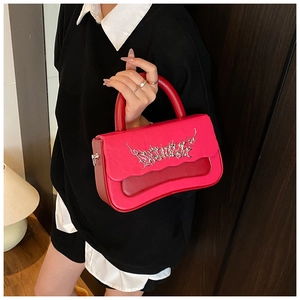 Detail of fuchsia leather handbag with wave edge and silver gothic metal hardware