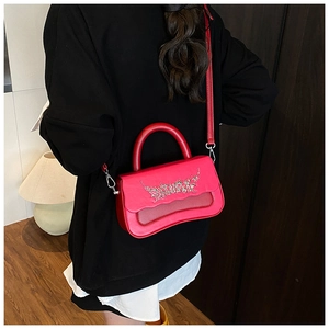 Rear view of a model carrying the red leather box bag with a silver artistic logo handle